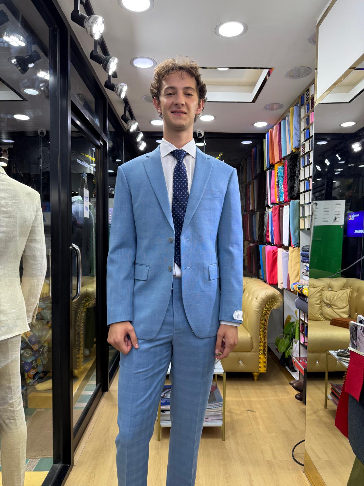 Customer wearing a light blue tailored suit with white shirt and navy tie